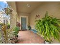 Inviting front porch with brick flooring, a seating bench, and lush plants and decorations at 17527 Stinchar Dr, Land O Lakes, FL 34638
