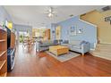 Bright living room with hardwood floors and sofas that leads to dining area and stairway at 17527 Stinchar Dr, Land O Lakes, FL 34638