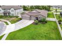 Aerial view of a well-manicured lawn, complemented by a two-car garage with decorative stone accents on home at 18079 Romanesque Ct, Spring Hill, FL 34610