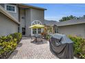 Relaxing outdoor brick patio featuring table, chairs, grill and colorful landscaping at 184 Hunter Ct, Palm Harbor, FL 34684