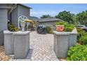 Brick patio with outdoor seating, grill, potted plants, and gray privacy walls at 184 Hunter Ct, Palm Harbor, FL 34684