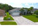 Inviting single-story home featuring a paver driveway, attached garage, and well-maintained landscaping at 1842 Ridgelake Ct, Wesley Chapel, FL 33543