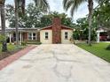 Attractive home with long concrete driveway, brick chimney, colorful landscaping, and mature palm trees at 2523 Krueger Lane, Tampa, FL 33618