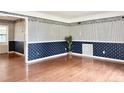 Bright living room with hardwood floors and decorative wallpaper with picture frame molding at 2523 Krueger Lane, Tampa, FL 33618