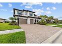 Beautiful home featuring a paver driveway, two-car garage, basketball hoop, and lush landscaping at 28565 Picana Ln, Wesley Chapel, FL 33543