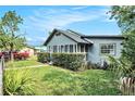 Cute home featuring an enclosed porch, tidy landscaping, and a partial lawn view at 3008 E Wilder Ave, Tampa, FL 33610