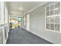 Enclosed front porch featuring screened windows, neutral carpet, and access to the home at 3008 E Wilder Ave, Tampa, FL 33610