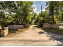 Long paved driveway leading to an estate home, lined with mature trees and brick pillars at 309 Hidden Lake Dr, Brandon, FL 33511