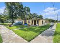Charming bungalow with a well-maintained lawn and covered car on a sunny day at 3201 E Mcberry St, Tampa, FL 33610