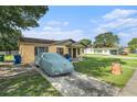 Charming bungalow with a well-maintained lawn and covered car on a sunny day at 3201 E Mcberry St, Tampa, FL 33610