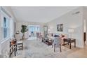 Bright and airy living room with light wood floors, large windows, and comfortable seating at 3271 Mcmath Dr, Palm Harbor, FL 34684
