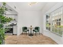Bright dining area with a modern table, green chairs, and a large window next to the modern kitchen at 409 S Audubon Ave # 3, Tampa, FL 33609