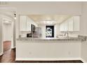 Open kitchen featuring white cabinets, granite countertops, stainless steel appliances, and a breakfast bar at 4342 Candler Ave, Spring Hill, FL 34609