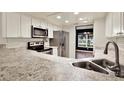 Bright kitchen with white cabinets, stainless steel appliances, and granite countertops at 4342 Candler Ave, Spring Hill, FL 34609