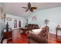 Cozy living room featuring hardwood floors, comfortable seating, and French doors leading to the pool area at 460 Meravan Dr, Palm Harbor, FL 34683