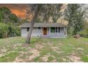 Charming single-story home featuring a cozy front porch and well-maintained lawn, perfect for outdoor relaxation at 5290 Cyril Dr, Dade City, FL 33523