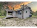 View of rear of the house with screened in porch and stairs to the yard at 5290 Cyril Dr, Dade City, FL 33523