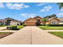 Inviting single-Gathering home with a spacious driveway, beautiful landscaping, and ample green space at 5303 Cottonwood Tree Cir, Valrico, FL 33596