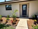 Inviting entryway showcasing a stylish blue front door, lush landscaping, and a welcoming walkway at 5435 20Th N Ave, St Petersburg, FL 33710