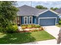 Charming blue single-story home with well-maintained landscaping and a spacious two-car garage at 11038 Spring Point Cir, Riverview, FL 33579