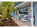 Cozy front porch adorned with seating, flowers, and a shade tree at 111 Carlyle Dr, Palm Harbor, FL 34683