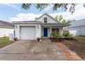 Charming single-Gathering home with a blue front door, manicured lawn, and attached one car garage at 1421 Dew Bloom Rd, Valrico, FL 33594