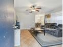 Open-concept living room featuring tile floors, ceiling fan and a comfortable seating area at 14732 Morning Dr, Lutz, FL 33559