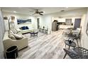 Open-concept living room featuring hardwood floors, modern decor, and seamless flow to the kitchen at 1515 E Hanna Ave, Tampa, FL 33610