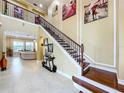 Spacious foyer featuring a grand staircase, decorative lighting, and tiled flooring at 1947 Marshberry Ct, Trinity, FL 34655
