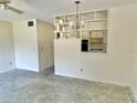 Spacious living room area featuring a ceiling fan and decorative wall shelving at 2391 Sumatran Way # 37, Clearwater, FL 33763
