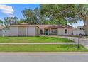 Charming single-story home with a well-manicured lawn and stone accents at 2824 Paddock Dr, Palm Harbor, FL 34684