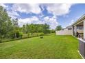 Expansive backyard with lush green grass, privacy fence, and view of natural surroundings at 2898 Living Coral Dr, Odessa, FL 33556