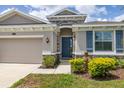 Close-up of the exterior with blue front door, stone accents, and a well-manicured lawn at 2898 Living Coral Dr, Odessa, FL 33556