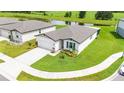 Aerial view of a home with a well-maintained lawn near a peaceful pond, offering serene suburban living at 3082 Forrest Plum Ct, Zephyrhills, FL 33540
