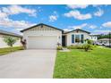 Charming single-Gathering home featuring a two-car garage, blue shutters, and vibrant landscaping at 3082 Forrest Plum Ct, Zephyrhills, FL 33540