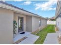 Neutral exterior of home featuring a side entry, neatly landscaped pathway, and privacy at 31814 Larkenheath Dr, Wesley Chapel, FL 33543