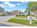 Charming single-story home with a well-manicured lawn and a two-car garage, enhancing its curb appeal at 31814 Larkenheath Dr, Wesley Chapel, FL 33543