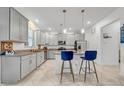 Modern kitchen with gray cabinets, stainless steel appliances, granite countertops, and island seating at 3216 Bryant Park Dr, New Port Richey, FL 34655