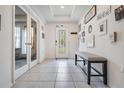 Bright foyer with decorative front door, tiled floor, high ceiling and bench at 344 Dartmouth Ave, Spring Hill, FL 34606