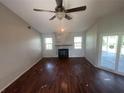 Spacious living room with wood-look flooring, fireplace, and access to a screened patio at 3541 65Th Avenue E Cir, Sarasota, FL 34243