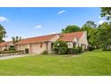 A bright house with a two-car garage, nice landscaping and a manicured lawn under a bright sky at 3687 Imperial Ridge Pkwy, Palm Harbor, FL 34684