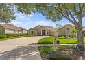 A view of the home from the street, showcasing the well-maintained lawn and mature landscaping at 3707 Smoke Hickory Ln, Valrico, FL 33596