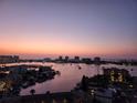 Sunset view of the water and city skyline from the condo featuring boats and buildings at 400 Island Way # 1606, Clearwater Beach, FL 33767