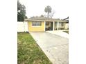 Charming single-story home with a large driveway and a yellow exterior with white trim and ample parking at 4111 W La Salle St, Tampa, FL 33607