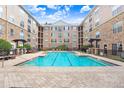 Inviting community swimming pool with brick surround, lounge chairs, and a view of the building's exterior at 4221 W Spruce St # 1429, Tampa, FL 33607
