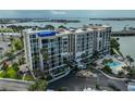 Full exterior of condo building showing updated facade, landscaping, and pool at 7400 Sun Island S Dr # 412, South Pasadena, FL 33707