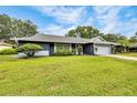 Charming single-story home with well-maintained lawn, mature trees, and a lush landscape at 7708 Fairlawn Dr, Hudson, FL 34667
