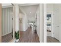 Bright hallway with wood flooring and an open view to the living area and bedroom at 7747 Wheat Stone Dr, Zephyrhills, FL 33540