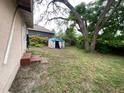 Backyard featuring a shed and plenty of grassy space, perfect for outdoor activities and storage at 8718 N Brooks St, Tampa, FL 33604