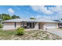 Charming home with a pergola-covered patio, gated entry, and a fresh exterior paint job under a blue sky at 9115 Panda Ln, Port Richey, FL 34668